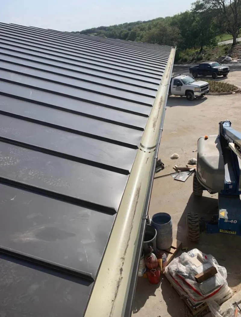 Standing seam panel and gutter detail on a metal roofing jobsite in Belterra